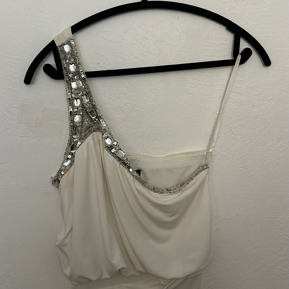 This is a white one shoulder with beaded crystals dress.